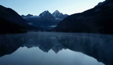 Nebeliger Alpensee‑Schweben